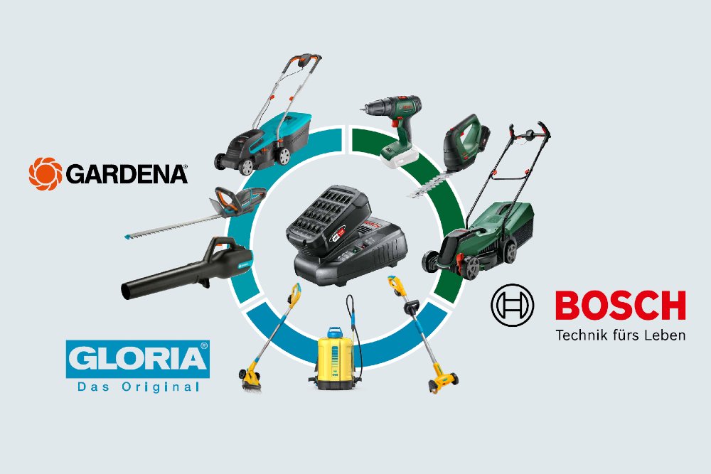 Verschiedene Gartengeräte um ein Akkuladegerät